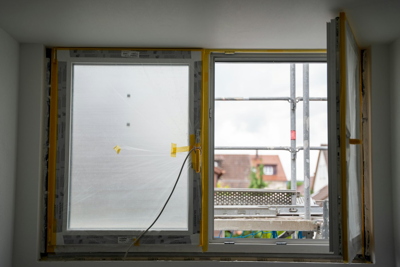 Ventana en instalación con marco nuevo y andamio afuera, termopanel en Chile